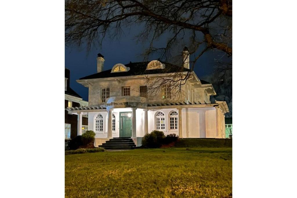 uma casa branca com uma porta verde à noite em Grand Old White Capitol Executive Suite em Charleston