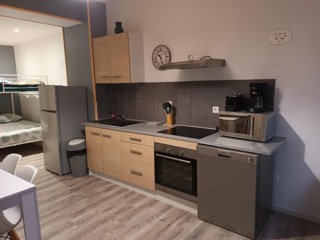 a kitchen with a sink and a stove and a refrigerator at La Riviera in La Fère