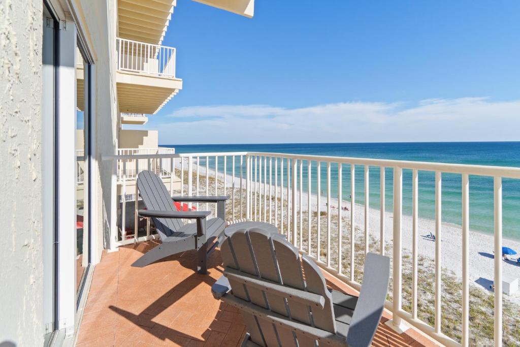 a balcony with two chairs and the beach at Sans Souci 407 in Pensacola Beach