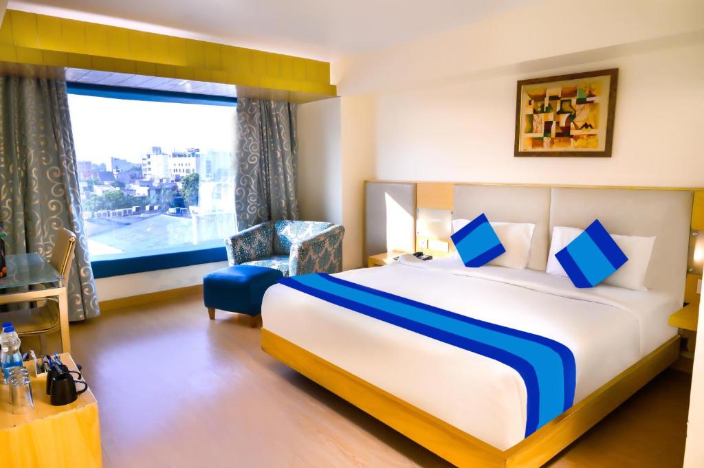 a hotel room with a large bed and a window at Keyonn Hotels & Resorts in Amritsar