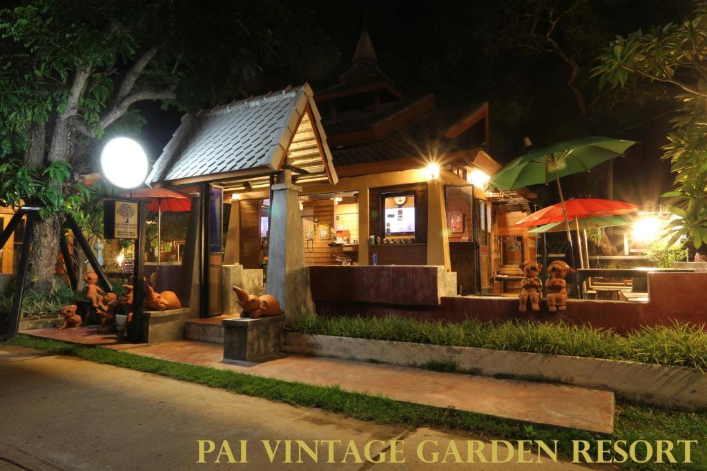 un restaurant le soir avec des gens assis dehors dans l'établissement Pai Vintage Garden Resort, à Pai