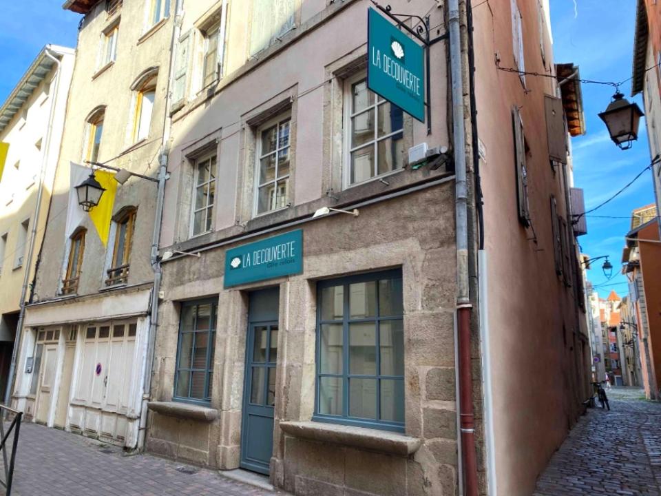 - un bâtiment sur une rue avec des panneaux de signalisation dans l'établissement Gite la découverte petit déjeuner offert, au Puy-en-Velay