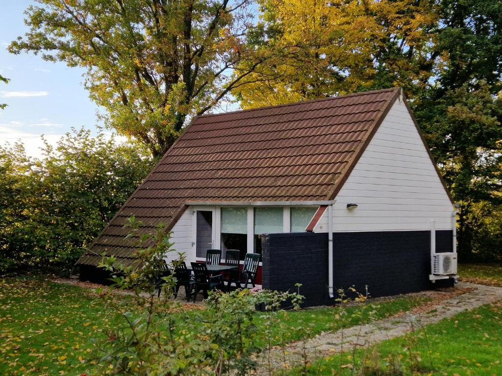 a small white house with a table and chairs at Huuske 086 in Simpelveld