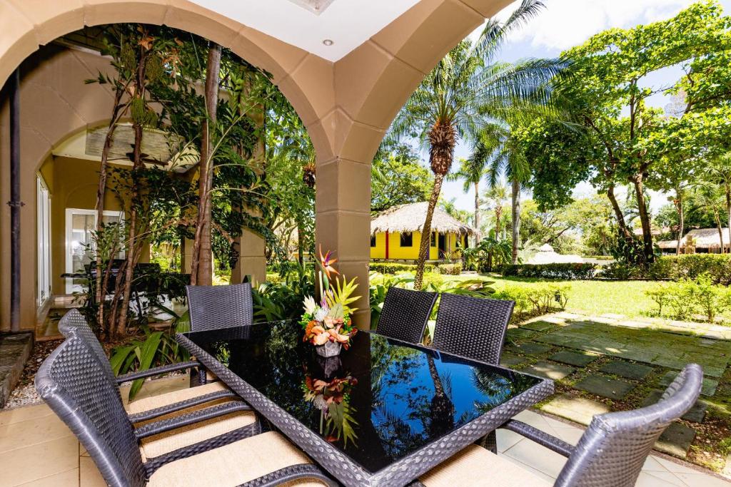 a dining table and chairs on a patio at Matapalo 104 -2 Bedroom Poolside Condo at the Diria Resort in Tamarindo