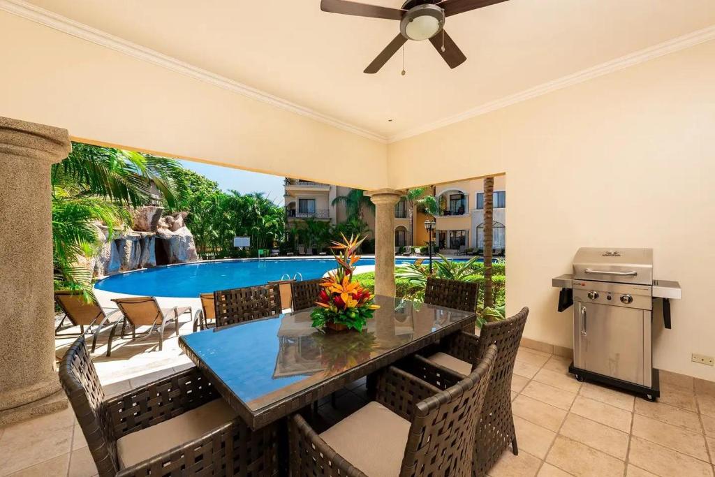 a dining room with a table and chairs and a pool at Sunrise 1- 3 Bedroom Poolside Condo in Tamarindo
