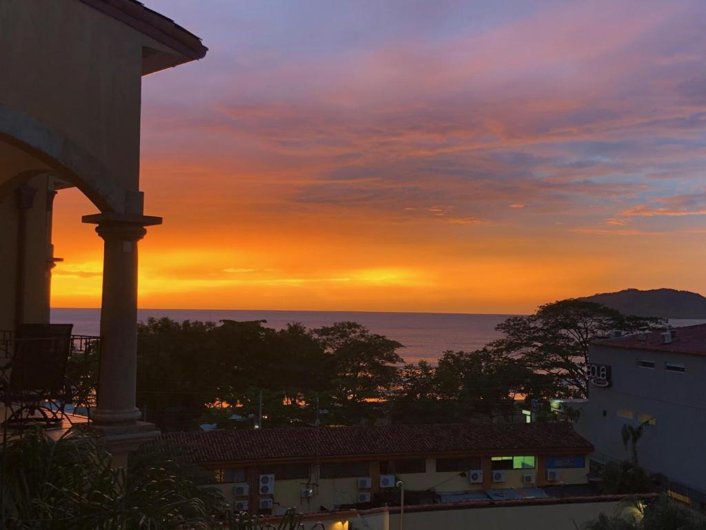 ein Gebäude mit Blick auf den Sonnenuntergang über dem Meer in der Unterkunft Sunrise 12- 2 Bedroom Ocean View penthouse in Tamarindo