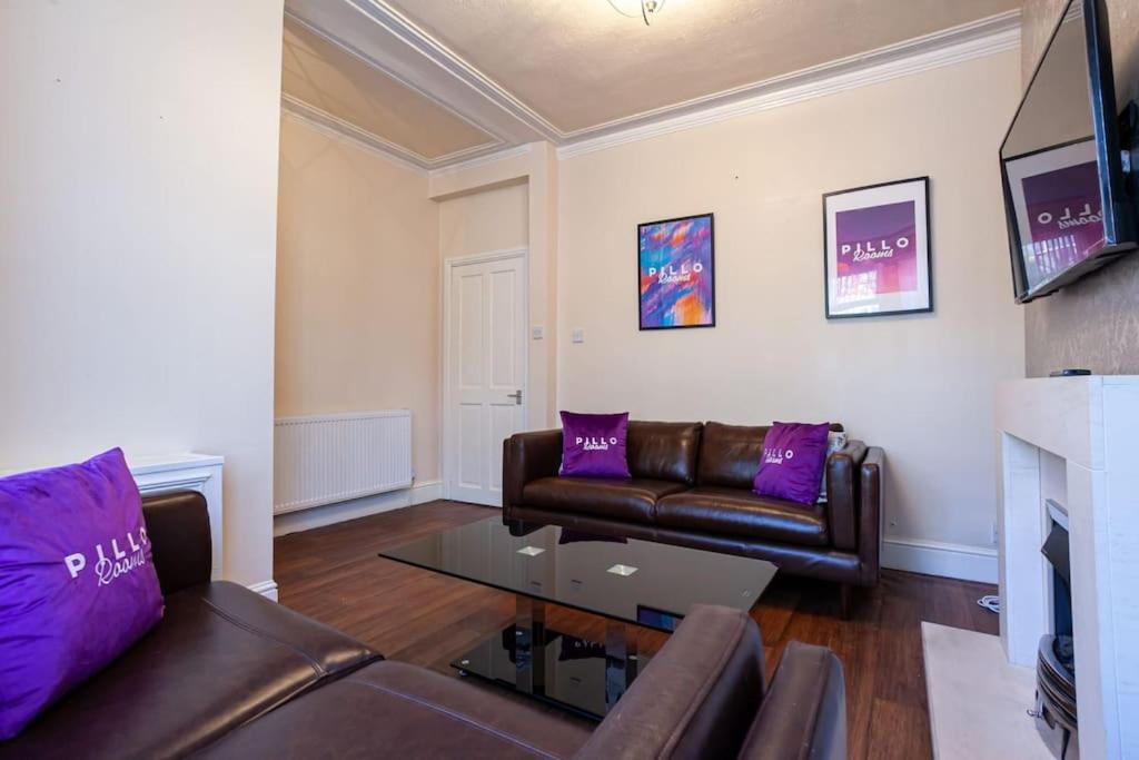 a living room with a couch and a table at Pillo Rooms - Spacious Cosy 2 Bedroom House by Bridgewater Canal in Manchester