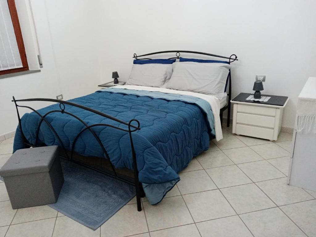 ein Bett mit blauer Decke in einem Schlafzimmer in der Unterkunft Fontana Nuova in Sardara