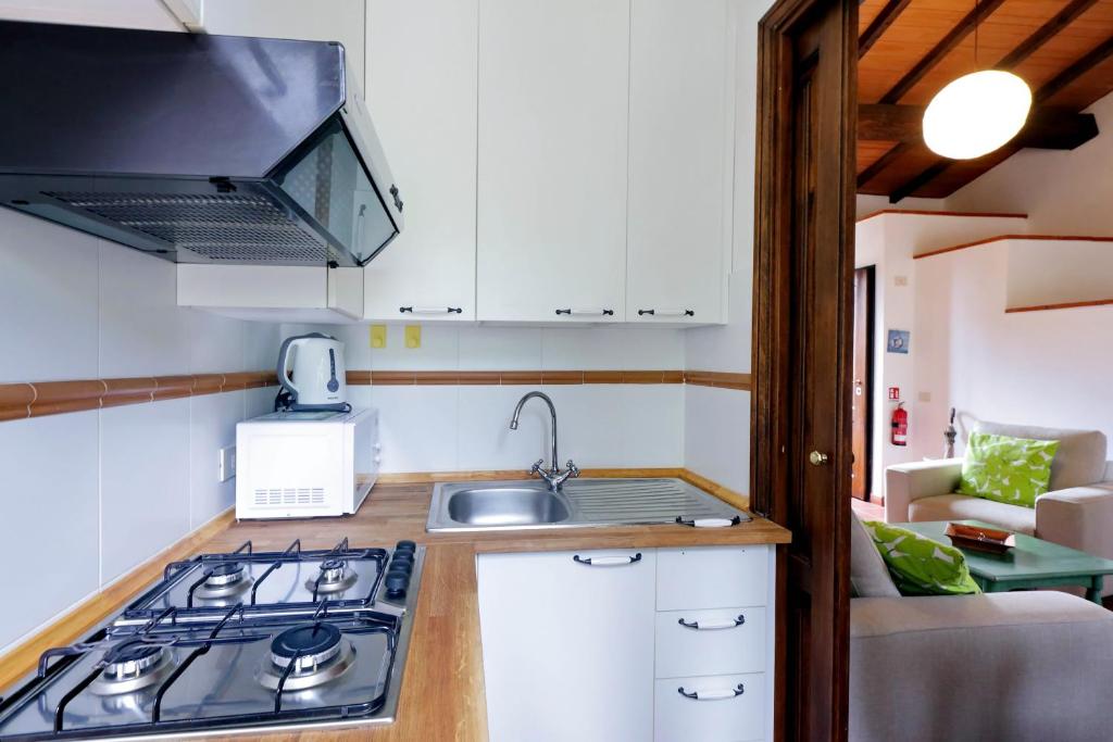a kitchen with a stove and a sink in a room at Agriturismo Pimpinnacolo in Porto Ercole