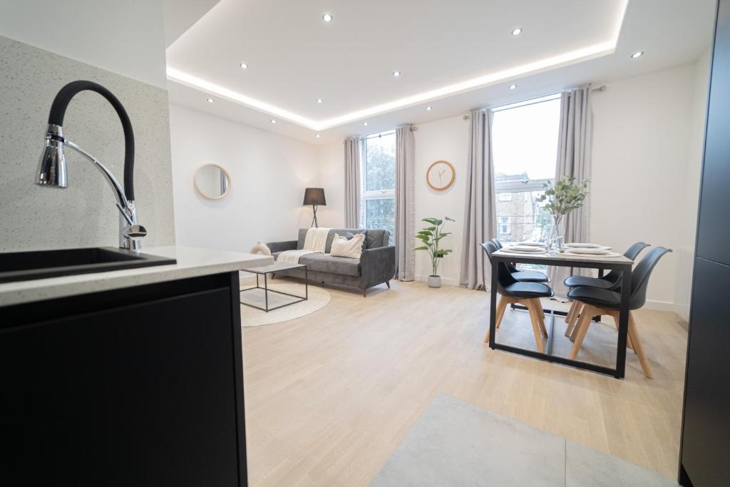 a kitchen and living room with a table and chairs at One & Two Bedroom Apartments near Holloway Train Station by Belvilla in London