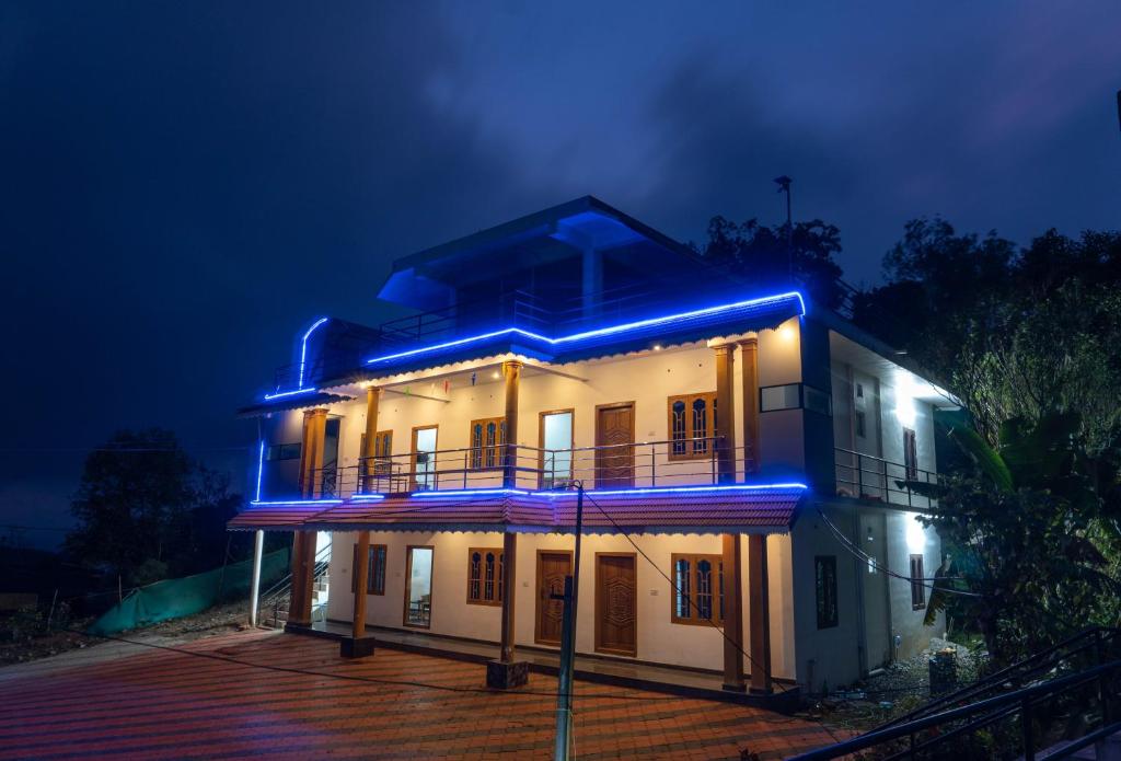 une maison avec des lumières bleues allumées la nuit dans l'établissement Namasthe Thekkady, à Thekkady