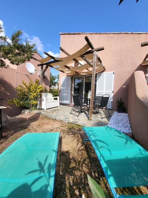 une planche de surf assise sur le sol devant une maison dans l'établissement MINI VILLA A 5MIN À PIEDS DE LA PLAGE SANTA GIULIA, à Porto-Vecchio