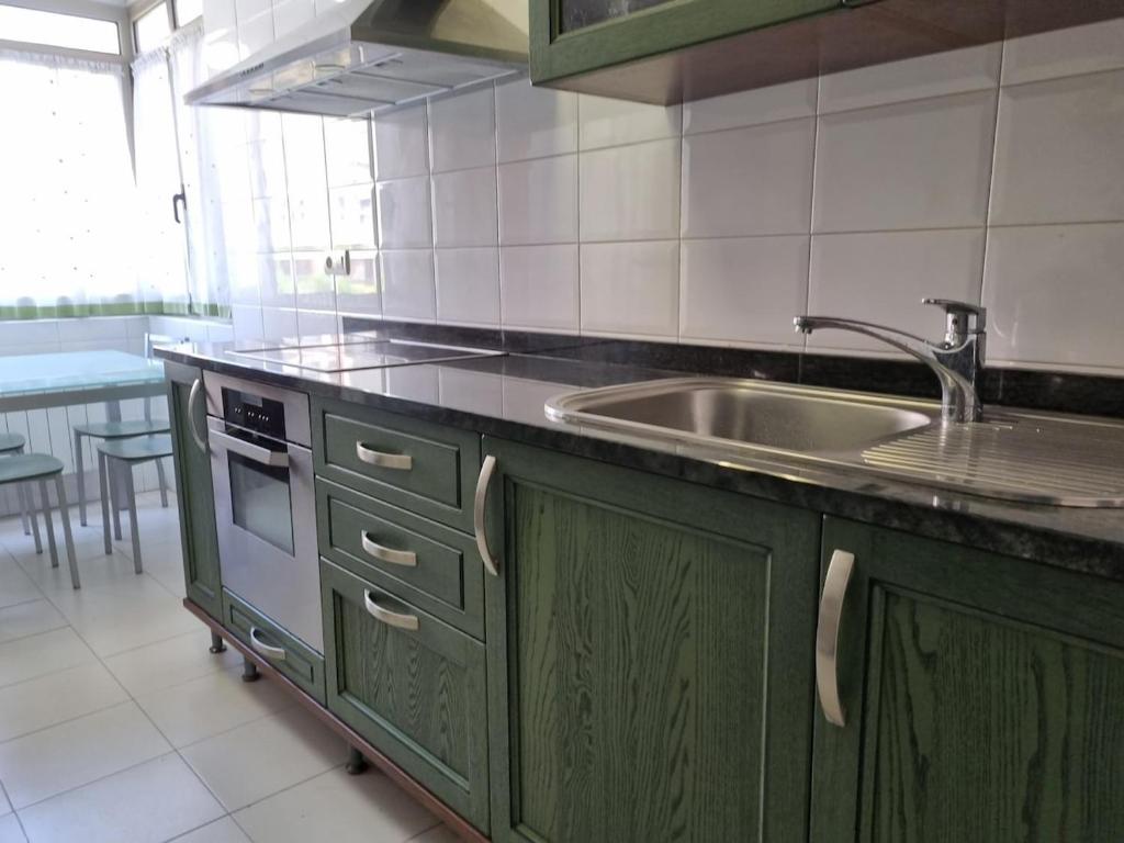 kuchnia z zielonymi szafkami i zlewem w obiekcie C01A03 Precioso apartamento Santander w mieście Santander