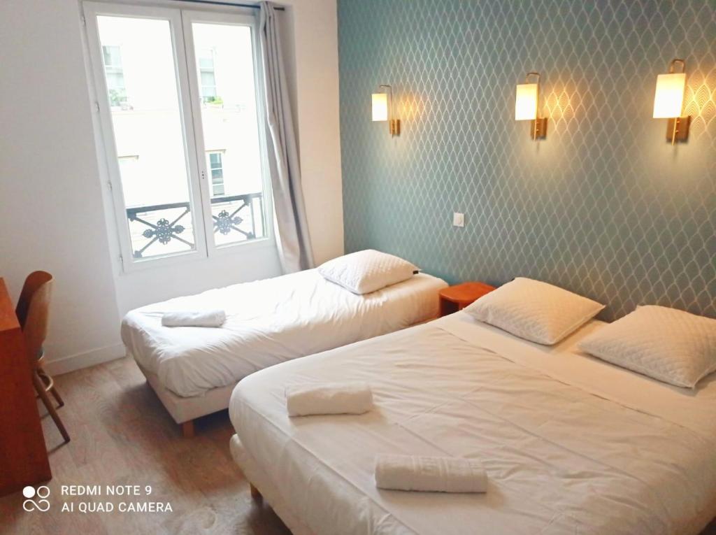 Cette chambre comprend 2 lits et une fenêtre. dans l'établissement Hôtel Central Bastille, à Paris