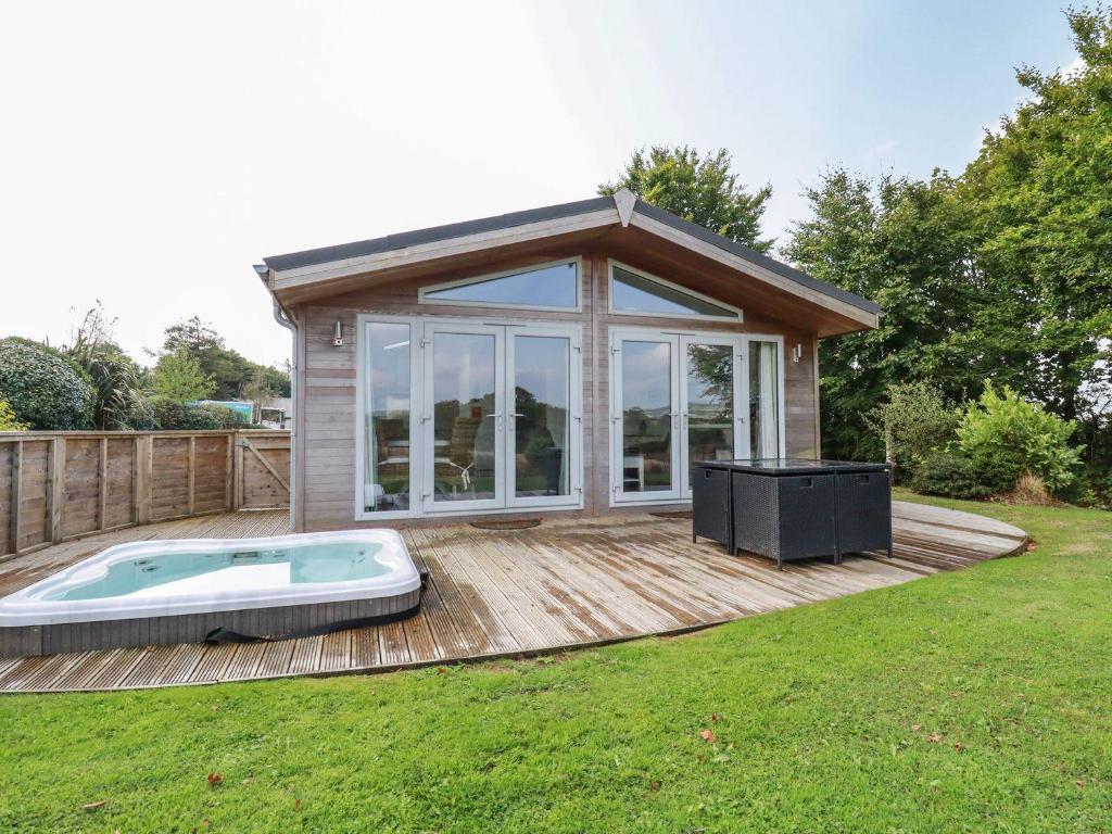 a pool house with a hot tub on a deck at 1 Horizon View in Liskeard