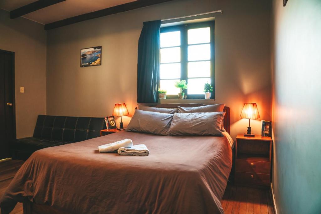 1 dormitorio con 1 cama con 2 toallas en Wild Rover La Paz, en La Paz