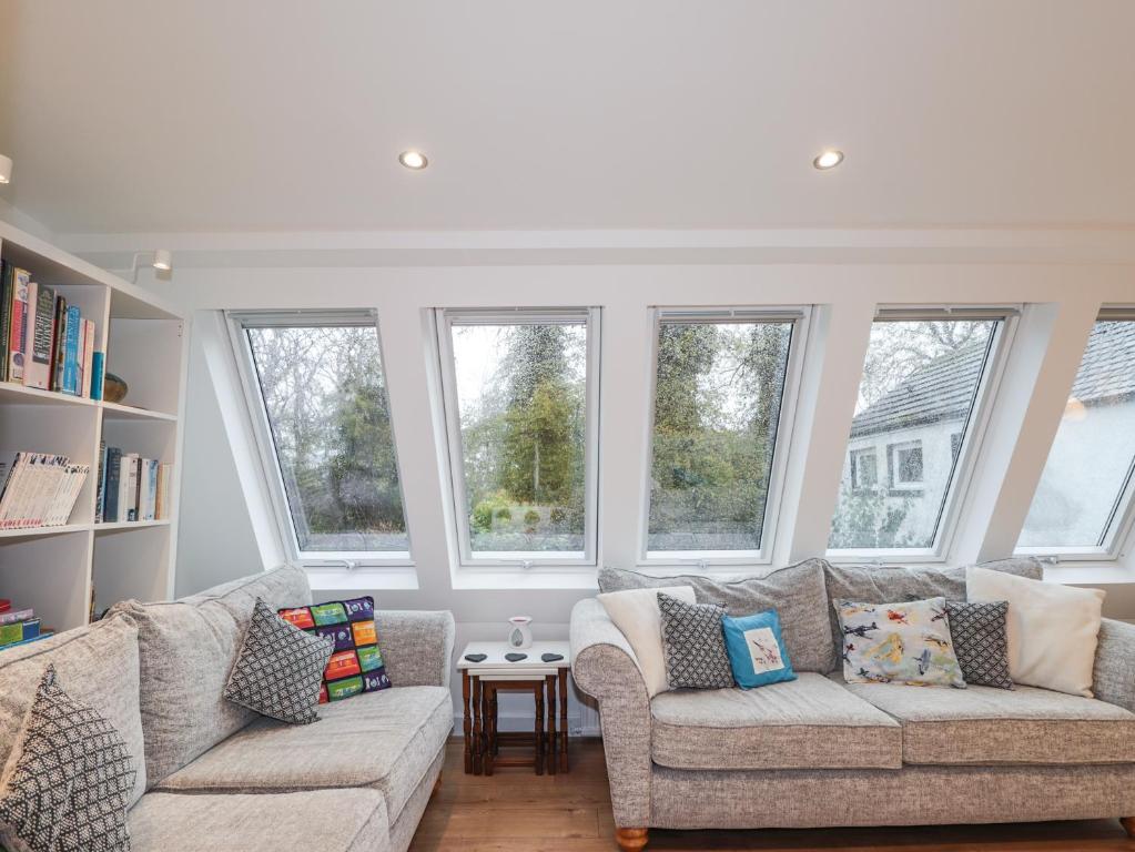 a living room with two couches and windows at 3 Dunrobin Street in Tain
