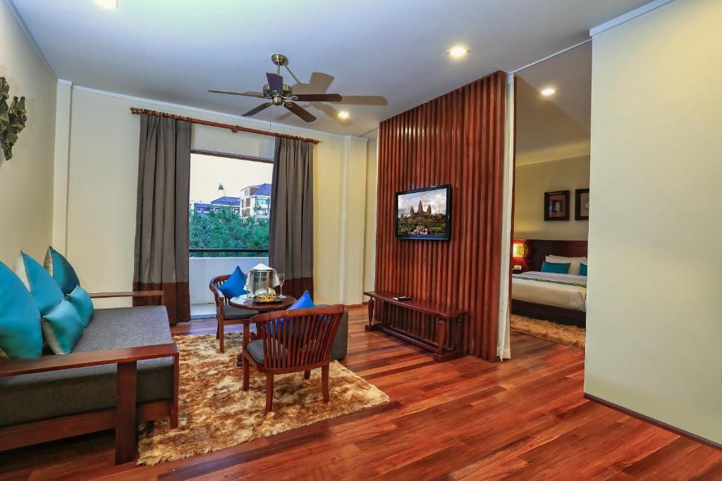 a living room with a couch and a table at Lotus Blanc Resort in Siem Reap
