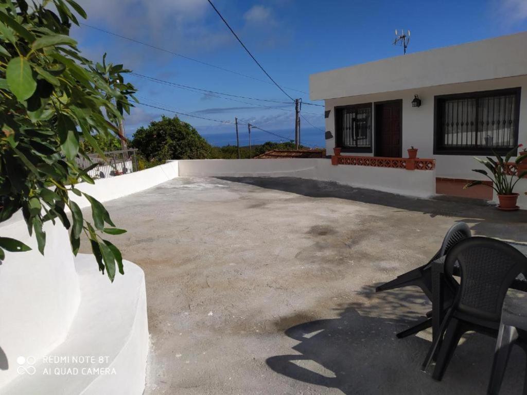 una silla negra sentada en un lado de una casa en Casa rural con Wifi, terraza y vistas al mar el La Palma, en Puntallana