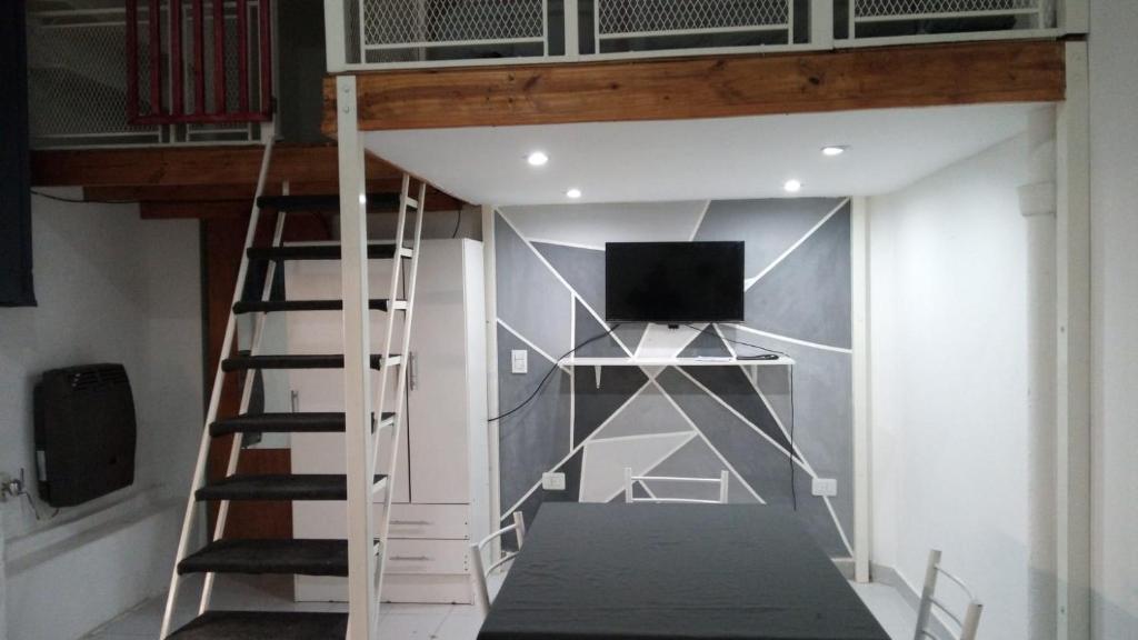 a loft bed with a tv in a room at Bless1 in Puerto Madryn