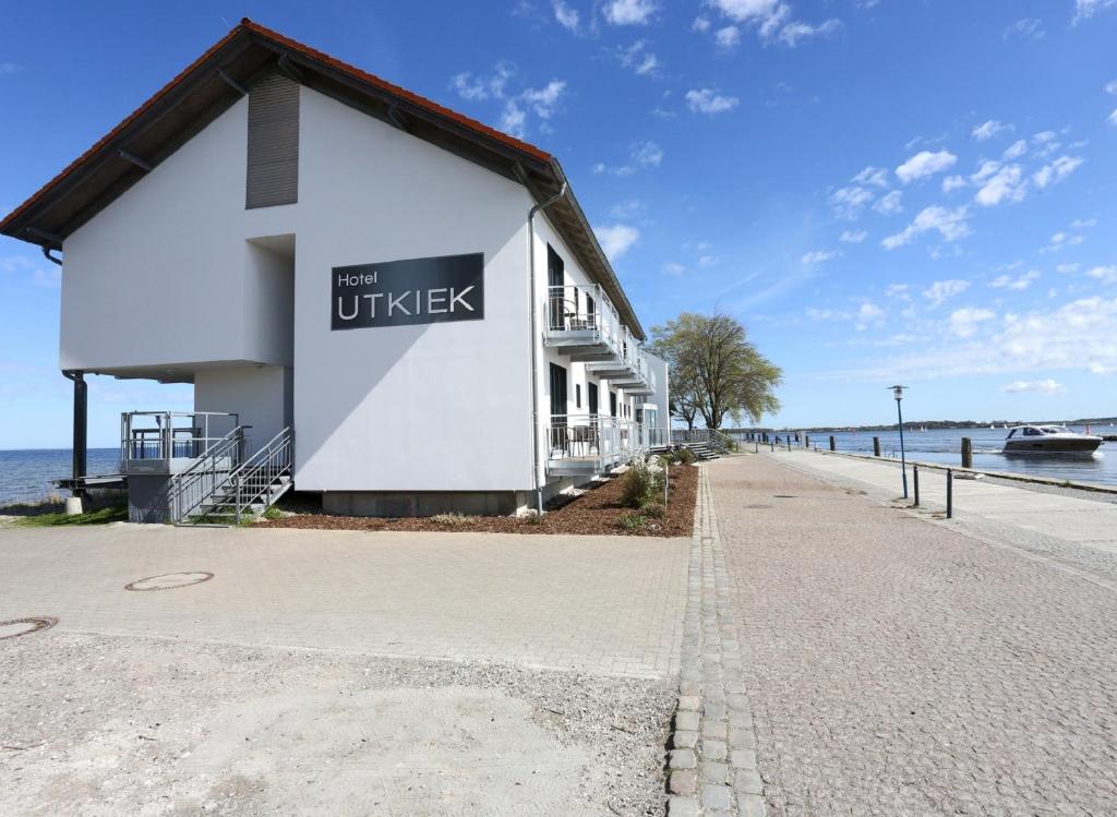 a building with a sign on it next to the water at Hotel & Restaurant Utkiek in Greifswald