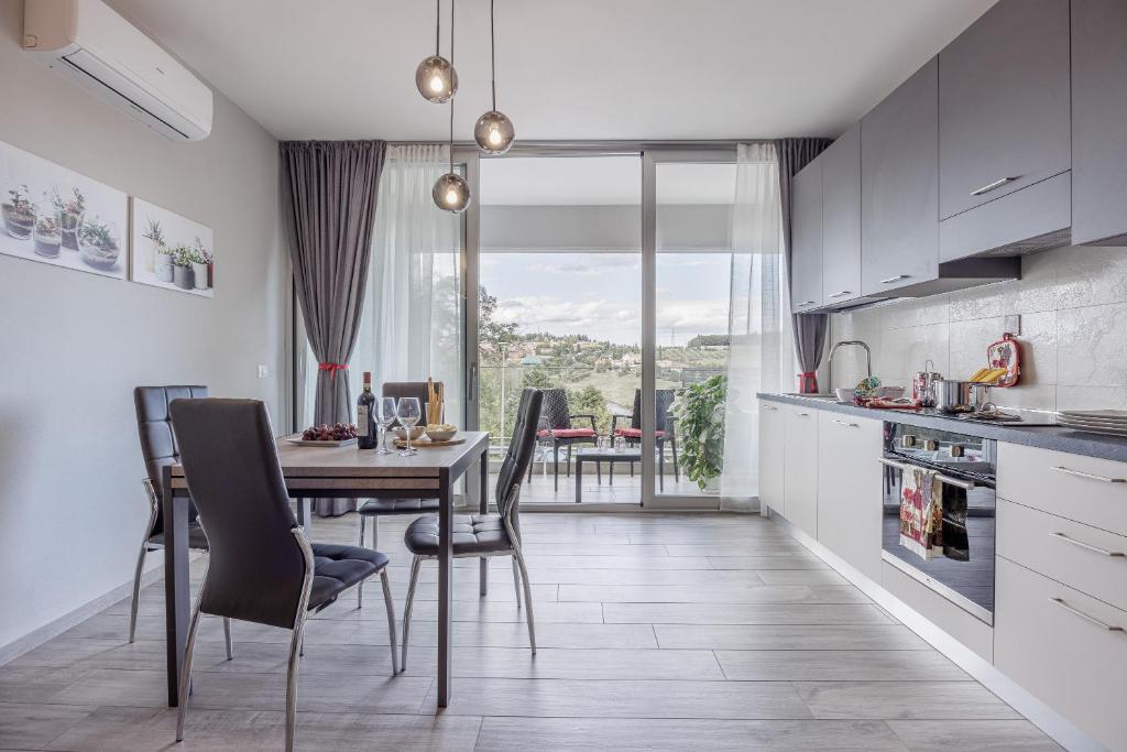 a kitchen and dining room with a table and chairs at Siena Living Apartment in Siena