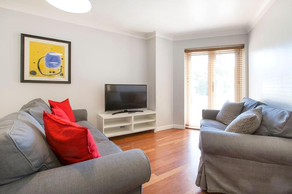 uma sala de estar com dois sofás e uma TV de tela plana em Cosy Modern Oxford Apartment em Oxford