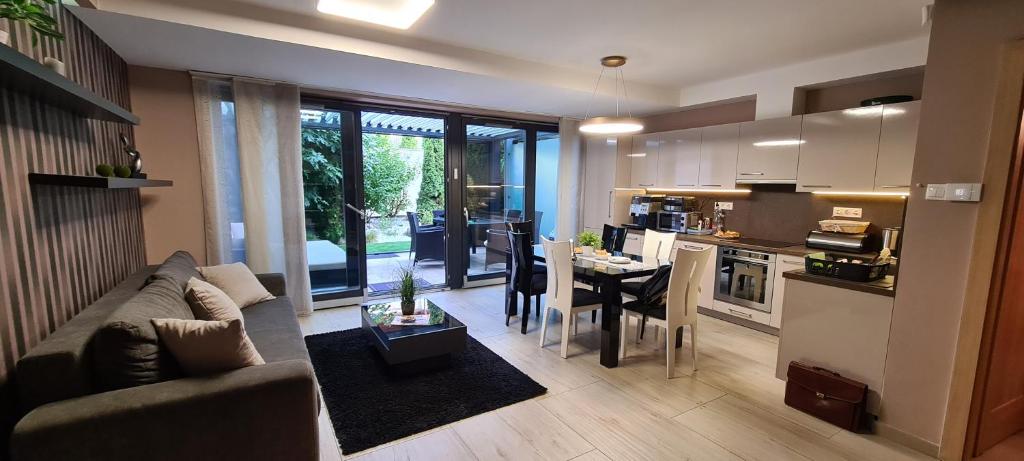 een woonkamer en een keuken met een bank en een tafel bij Villapark Pleasure Apartment in Balatonfüred