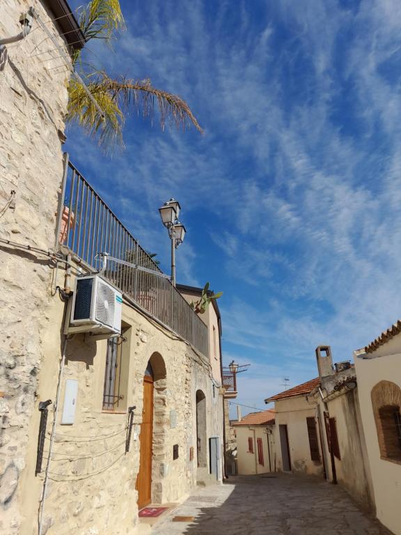 an alley in a town with a building with a balcony at Sognando nel borgo in Rocca Imperiale