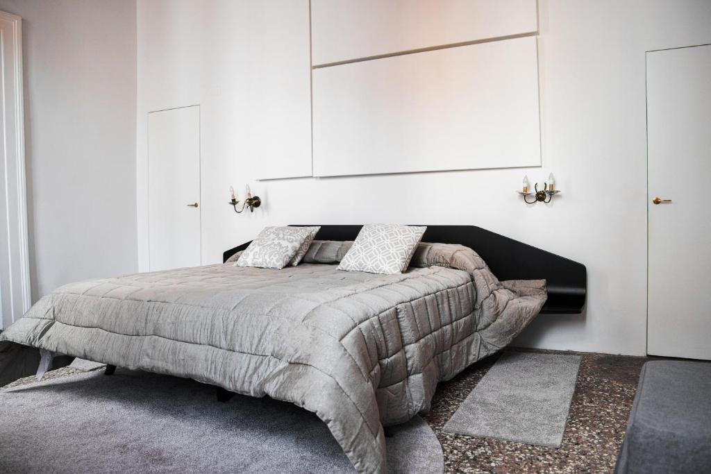 Schlafzimmer mit einem Bett mit einem großen Kopfteil in der Unterkunft Cà Mascaròn in Venedig