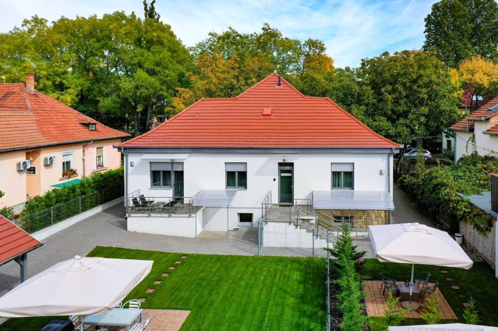 Casa blanca con techo naranja y patio en Villa Garden, en Eger