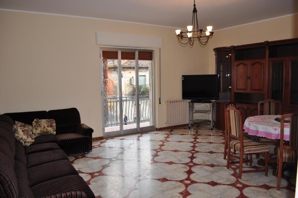 salon z kanapą i stołem w obiekcie Casa Catena w mieście Francavilla di Sicilia