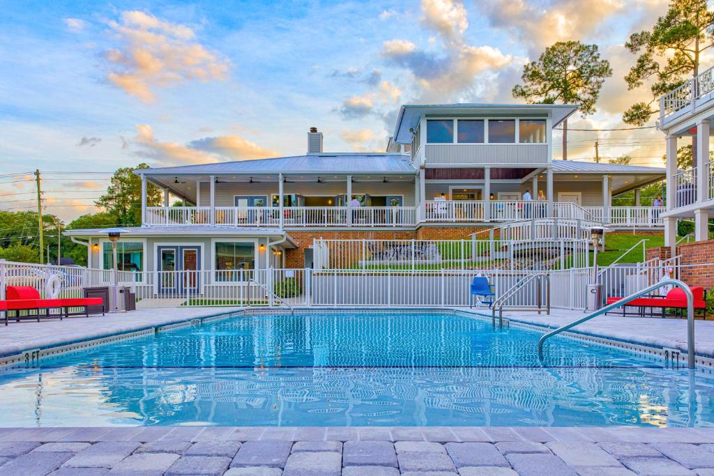 a house with a swimming pool in front of a house at Seven Hills Suites I-10 in Tallahassee