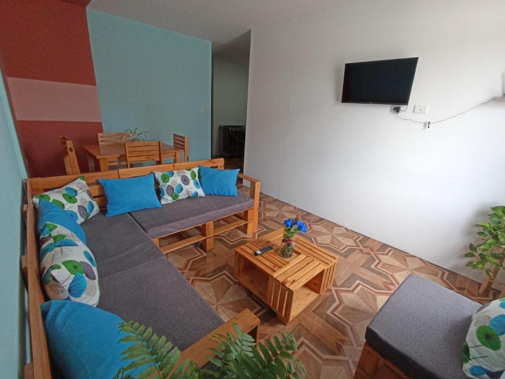 ein Wohnzimmer mit einem Sofa und einem TV in der Unterkunft Departamento familiar en Manta in Manta