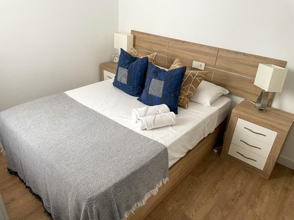 a bedroom with a large bed with blue pillows at Apartment Los Boliches Fuengirola Malaga Spain in Fuengirola