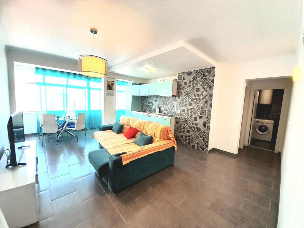 sala de estar con sofá y cocina en Apartamento T1 Tropical 200mt from the beach, en Armação de Pêra