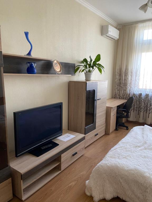 a bedroom with a flat screen tv and a bed at Rent Kiev Apartment 2 min metro Chernihivska in Kyiv