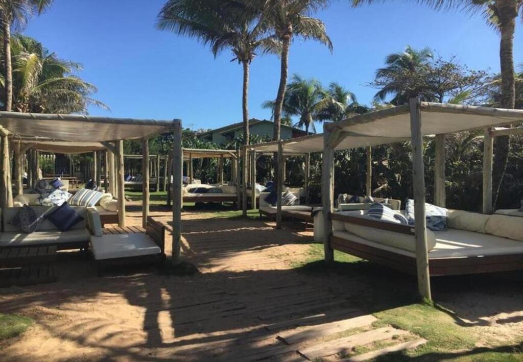 um grupo de camas num resort com palmeiras em Sol de Bora Bora 103 em Salvador