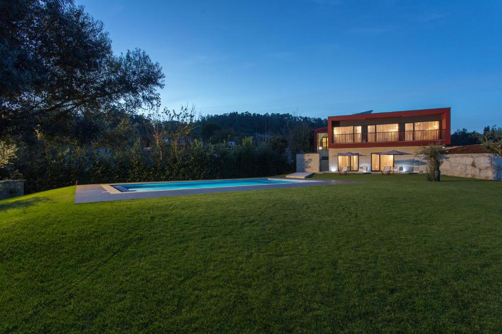a house with a large yard with a swimming pool at Casa de Campo Sossego da Lata in Fafe