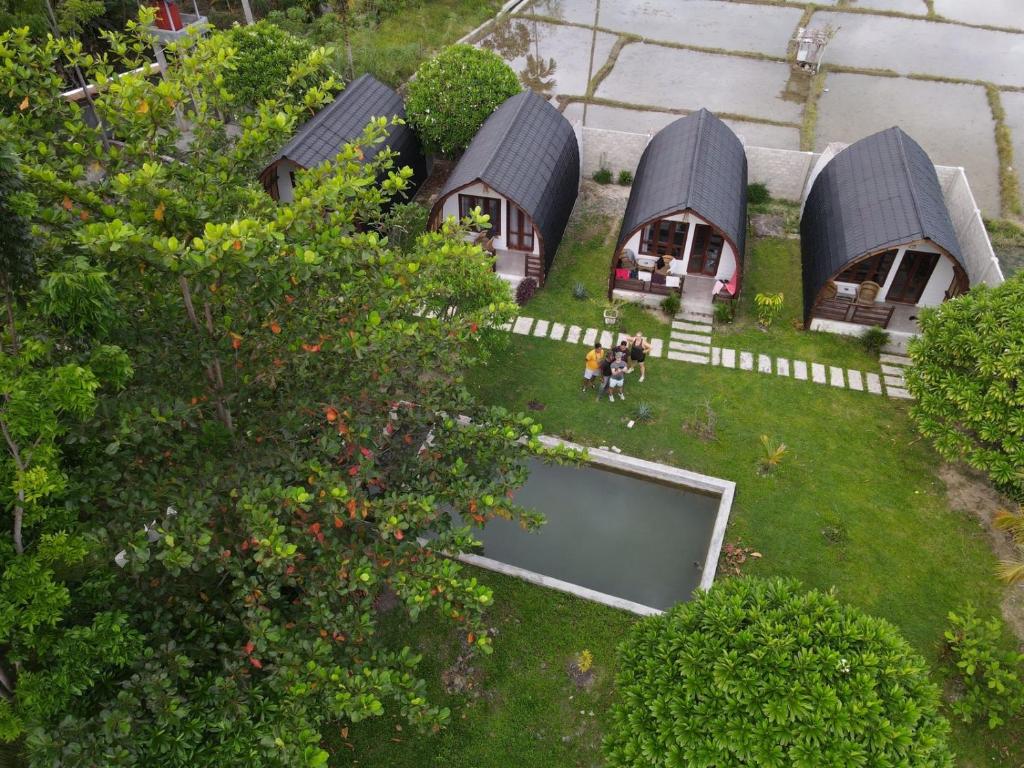 an aerial view of a house with people standing in the yard at Gino's Place - Bungalows and Restaurant in Bukit Lawang