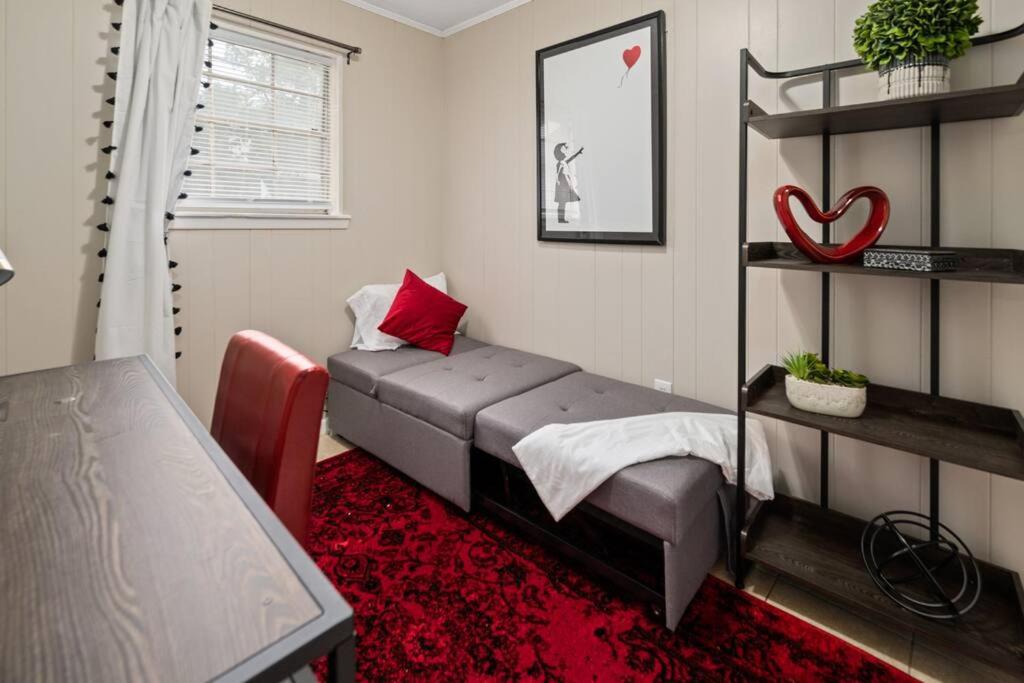 1 dormitorio con cama y alfombra roja en HEIRS LIVING : LUV SHACK - Near Rapides Regional Medical Center . Pet Friendly . King Bed . Free Parking . Fast WiFi, en Pineville