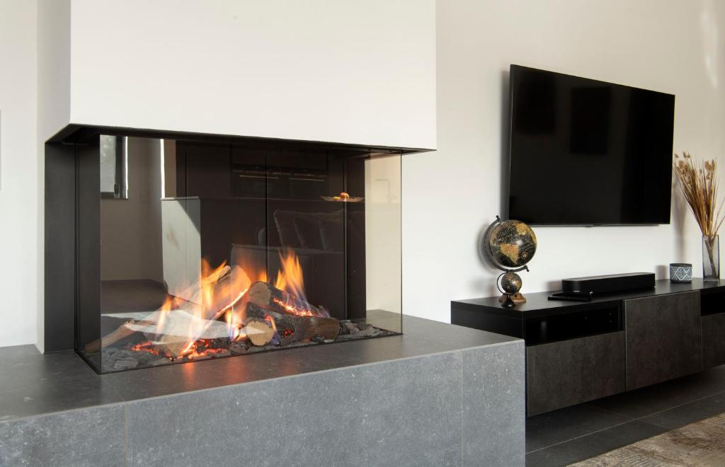 a living room with a fireplace and a tv at Luxus Penthouse mit Kamin und Sonnenterasse in Hau