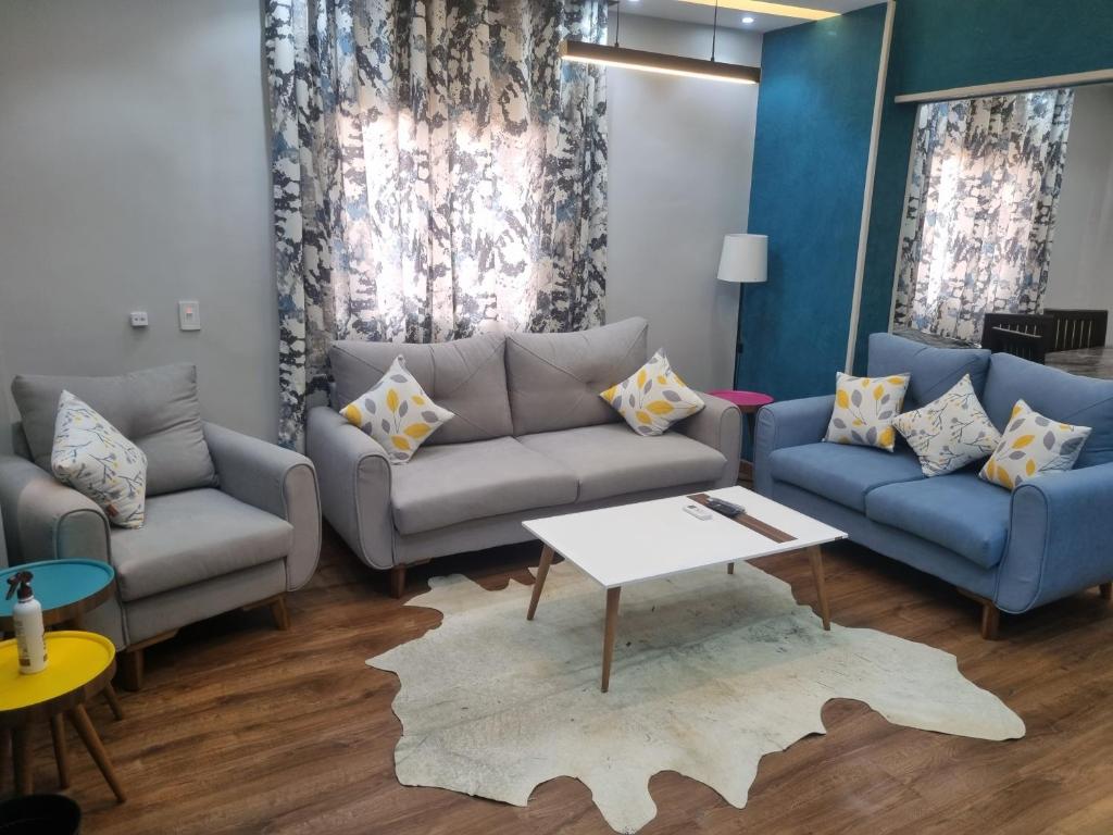 ein Wohnzimmer mit Sofas und einem Tisch in der Unterkunft Elite apartment in Mohandessin in Kairo