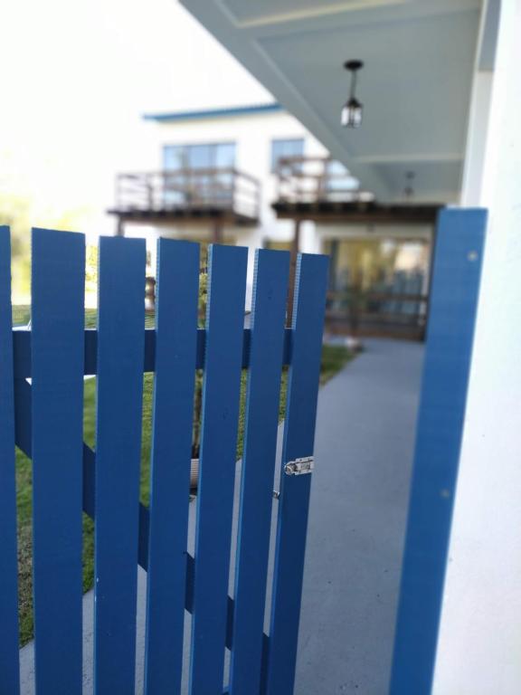 a blue fence in front of a house at Bella Ciao Hospedaria in Passo de Torres