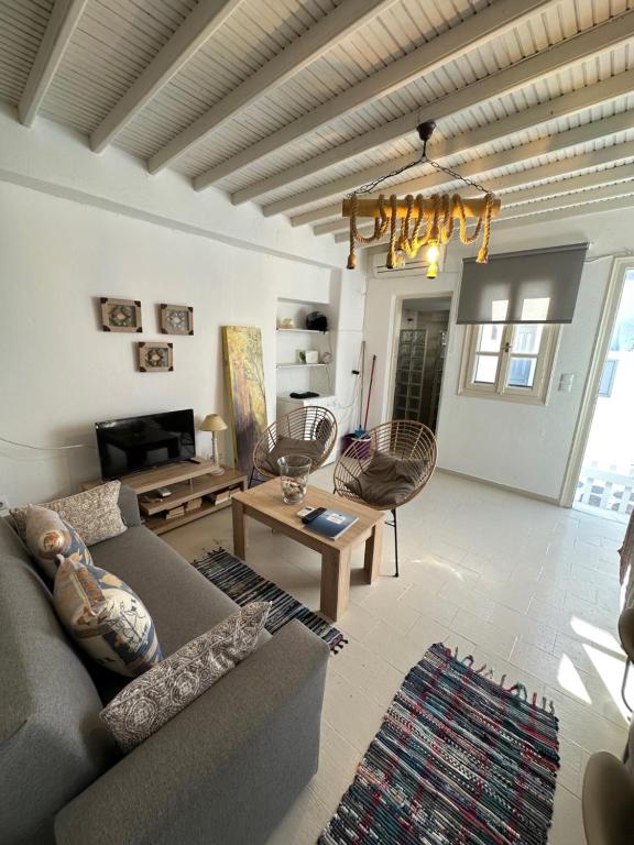 a living room with a couch and a table at Myconian Avra Apartment in Megali Ammos