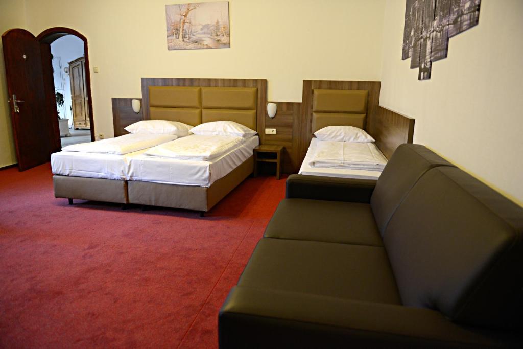 ハンブルクにあるITM Hotel Motel21 Hamburg-Mitteのベッド2台とソファが備わるホテルルームです。