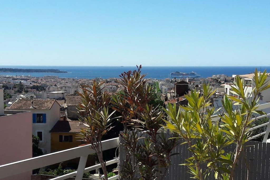 vista su una città con palme e sull'oceano di Studio vue mer panoramique sur la baie de Cannes a Le Cannet