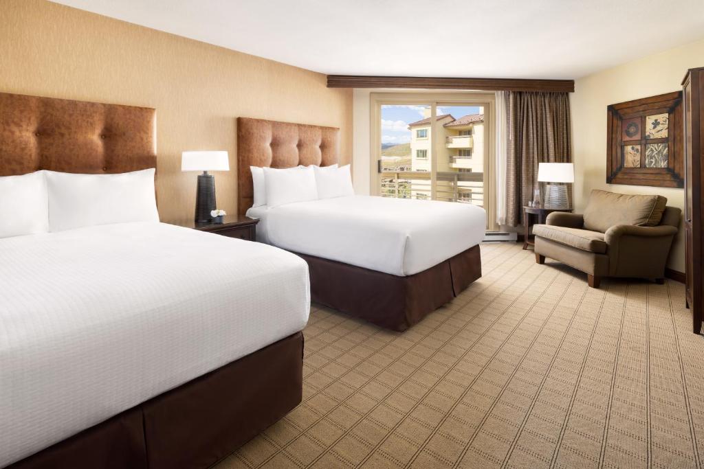 a hotel room with two beds and a chair at Elevation Hotel & Spa in Crested Butte
