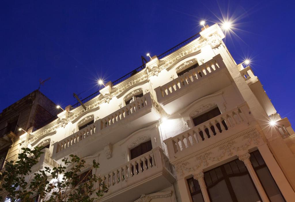 een wit gebouw met 's nachts verlichting bij Click&Flat Seneca Suites in Barcelona