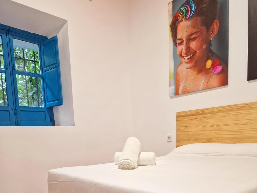 a bedroom with a painting of a woman on the wall at Arc House Mezquita - Only adults in Córdoba